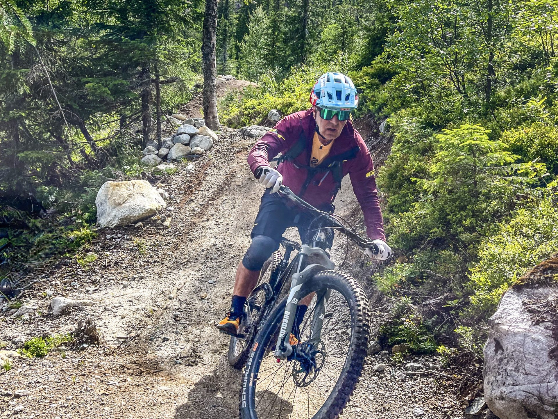 Mountain biker tackling rugged trail in forest, showcasing skills. Explore 