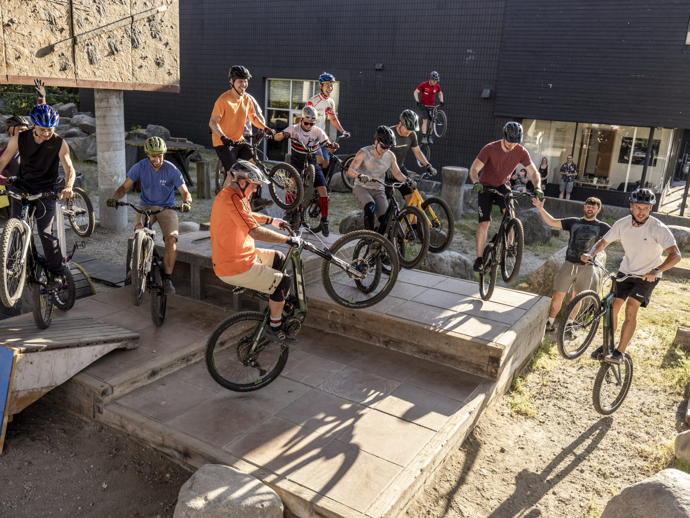 Group of mountain bikers performing tricks on urban terrain. SEO keywords: Hans Rey, mountain biking, cycling skills, bike tricks, outdoor activity. Mountain Bike United.