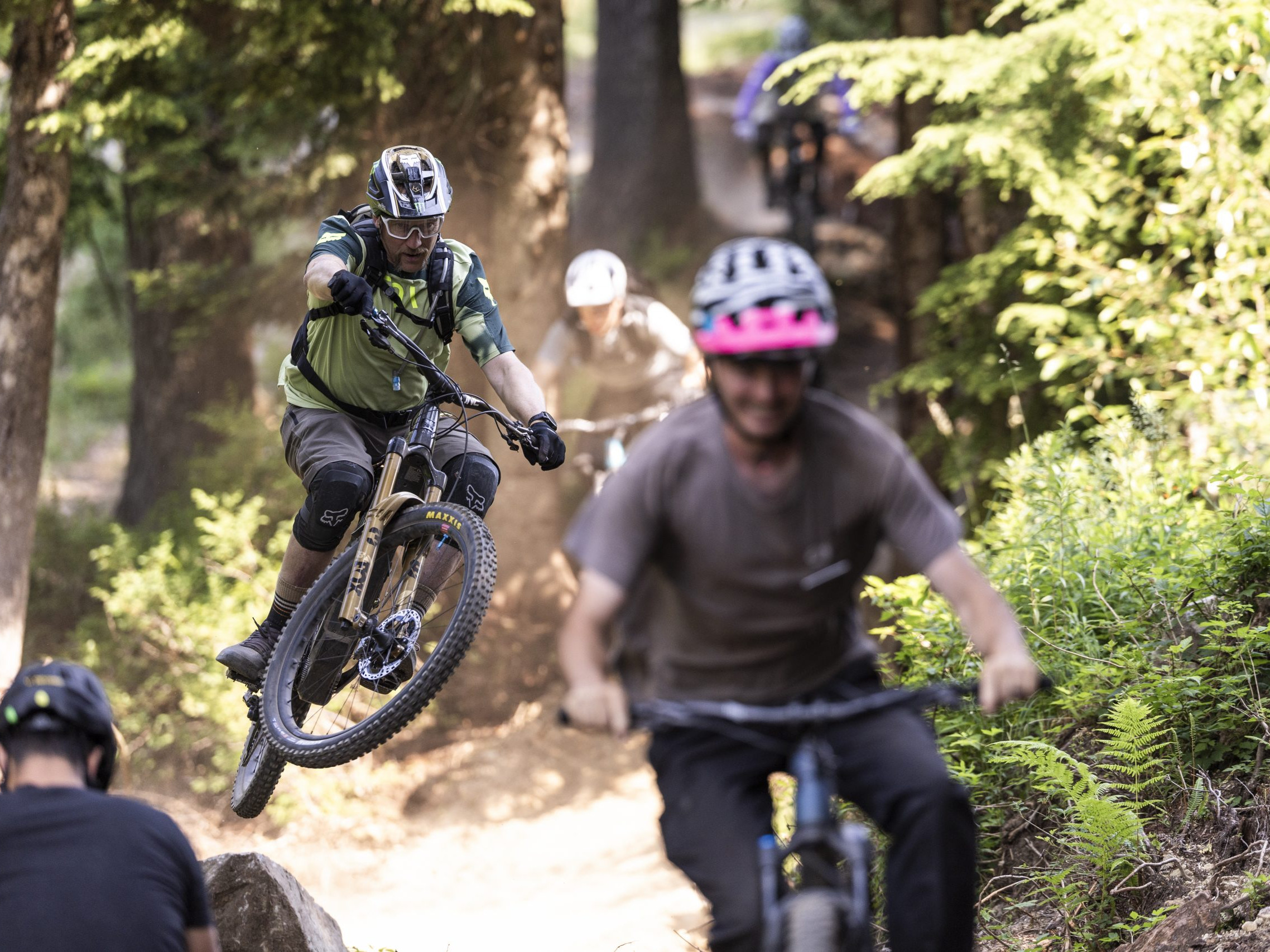 Mountain bikers navigating forest trail, highlighting outdoor adventure and enthusiasm for cycling, reminiscent of Hans Rey's biking style. Mountain Bike United.