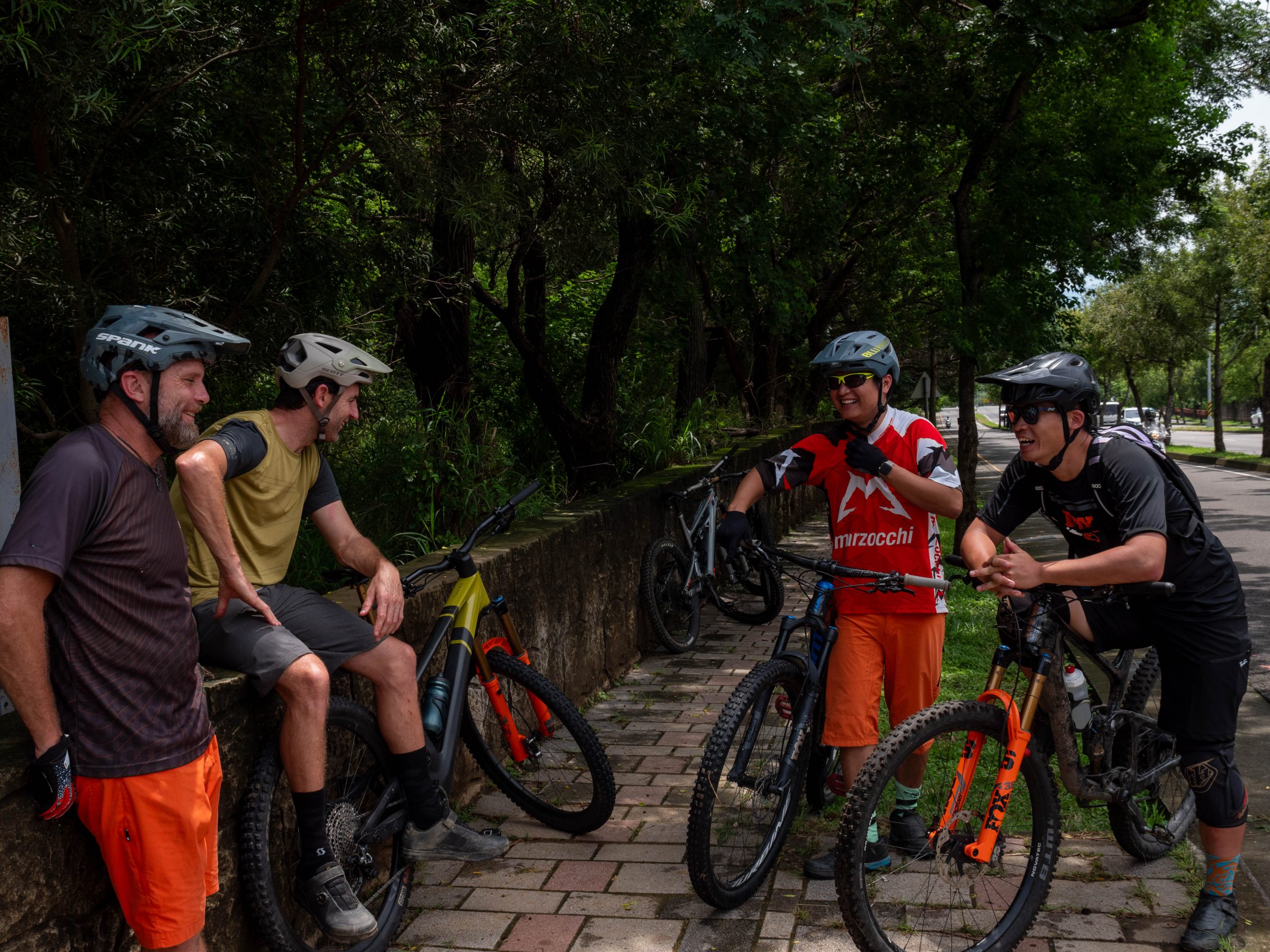 Group of mountain bikers on a trail break, discussing 